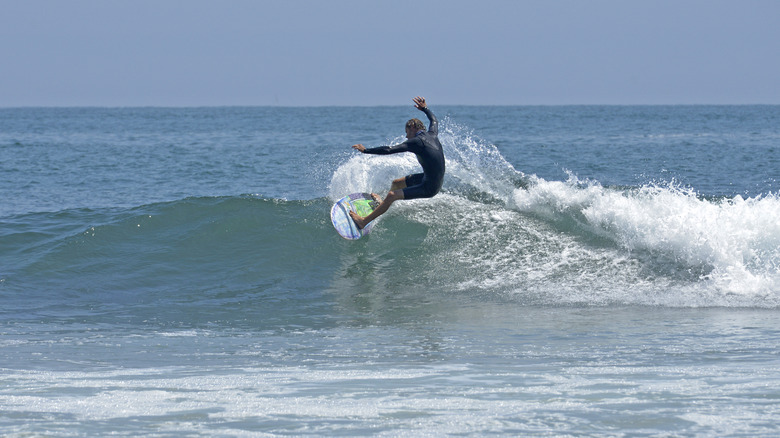 A surfer riding a small wave at Topanga Beach, near Santa Monica, California.