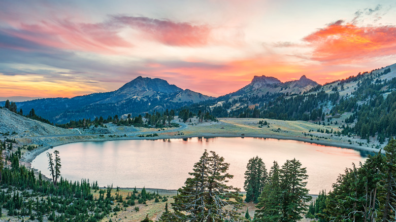 A lake ringed by mountains and trees at sunset at Lassen Volcanic National Park