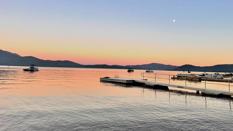 Sunset over a marine with three boasts on the water at Lake Almanor, in California.