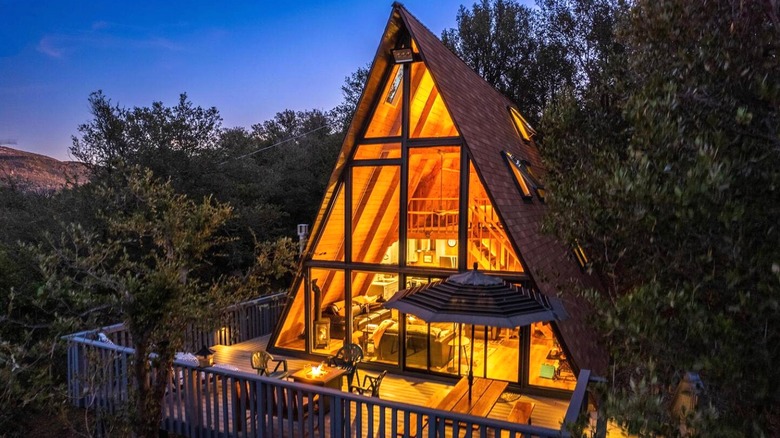 The exterior of the Airbnb with a view of the A-frame with floor-to-ceiling windows
