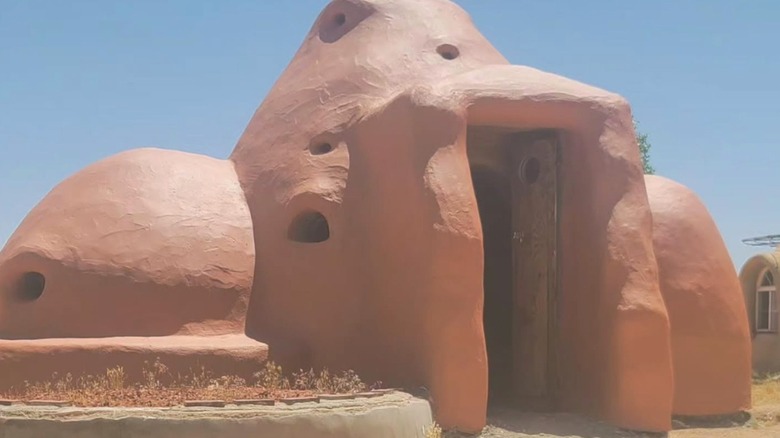 Photo of a red superadobe structure at Cal Earth Homes, Hesperia