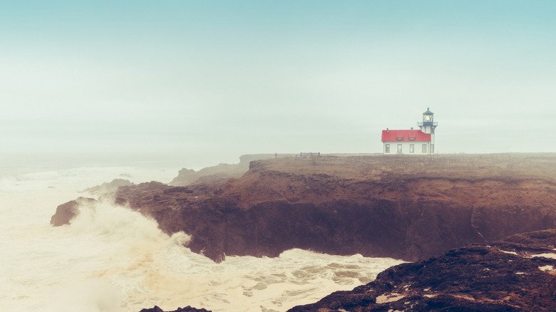 Point Cabrillo Lighthouse surrounded by fog with waves crashing on the beach