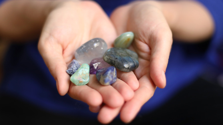 A collection of colorful gemstones in the palm of a hand