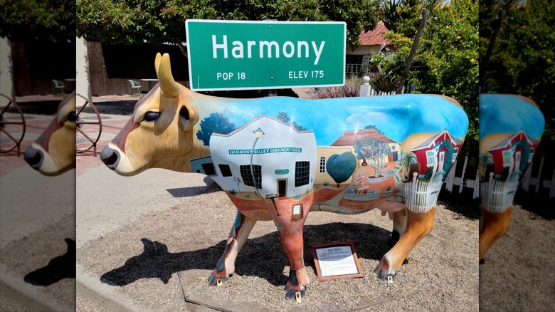 Cow sculpture outside the town sign for Harmony, California