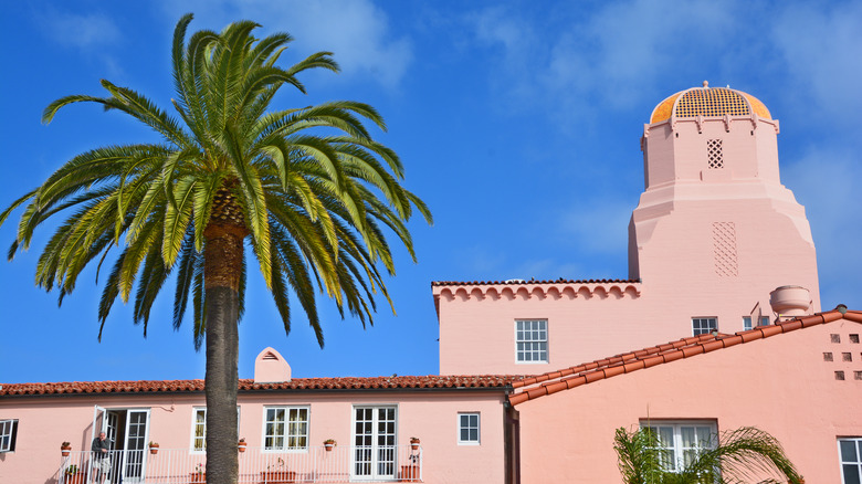 Palm tree fronts pink-hued La Valencia Hotel in La Jolla, California