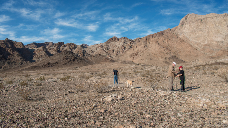People looking for fossils and hiking within the Marble Mountains in the Mohave Desert
