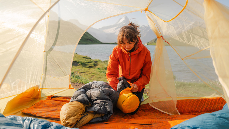 A female camper packing her sleeping bag