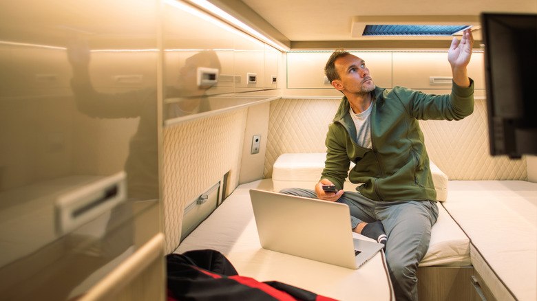 A man sitting on an RV bed with his laptop