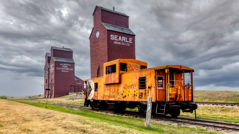 grain elevators and a vintage rail car in abandoned Rowley ghost town in Alberta, Canada