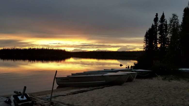 Boats on the shore of Reindeer Lake in Saskatchewan at sunset