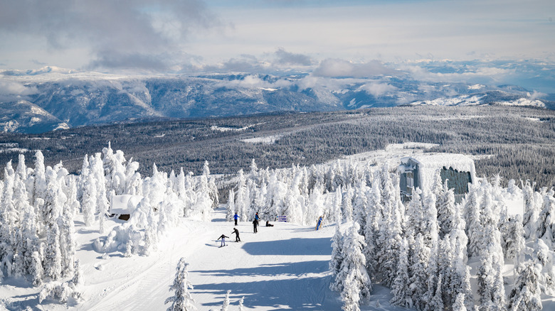 Skiers and snowboarders at Sun Peaks Ski Resort, with panoramic views of the surrounding mountains