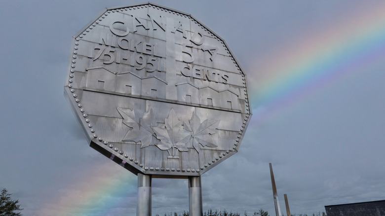 Rainbow stretches behind Big Nickel sculpture in Sudbury, Canada