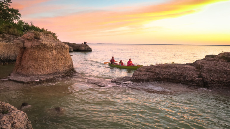 A canoe among limestone rock formations at Steep Rock Beach in Manitoba during sunset