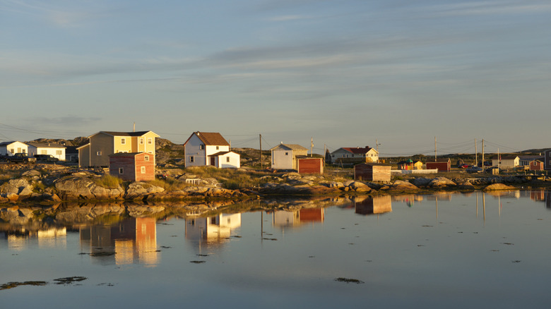 Vibrant saltbox homes, reflected in the water, on Fogo Island in Newfoundland and Labrador in Canada