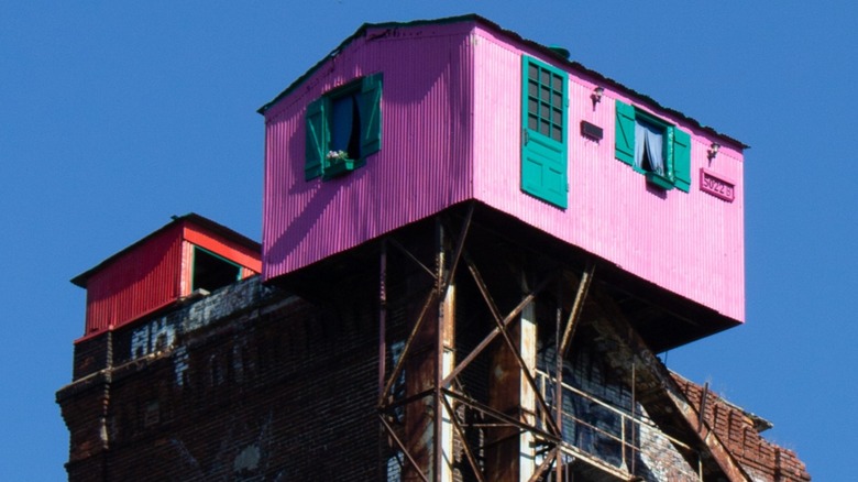 Pink and red houses street art atop abandoned malt silos in Saint-Henri, Montreal.