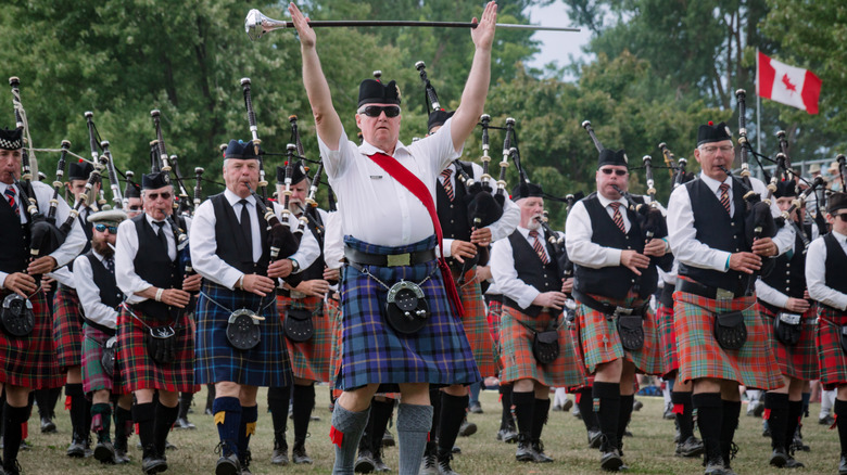 A kilt-wearing bagpipe band performing at the Fergus Scottish Festival and Highland Games