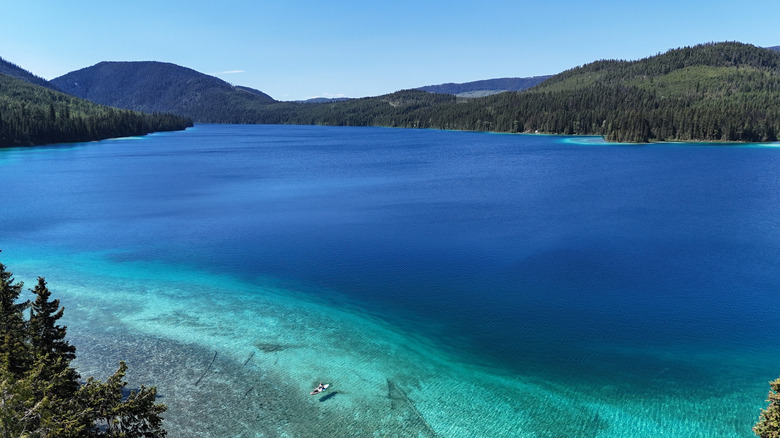 A watercraft in the turquoise-blue waters of Johnson Lake in British Columbia, surrounded by hills