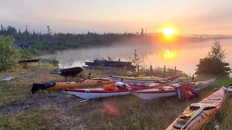 Kayaks and gear on a misty shoreline at sunset on Michipicoten Island