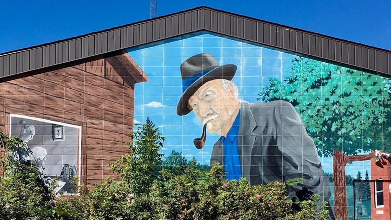A mural of old man with a pipe, with bush in foreground in Legal, Canada