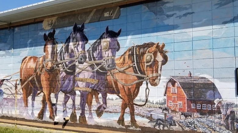A mural of four horses and a red barn in Legal, Canada