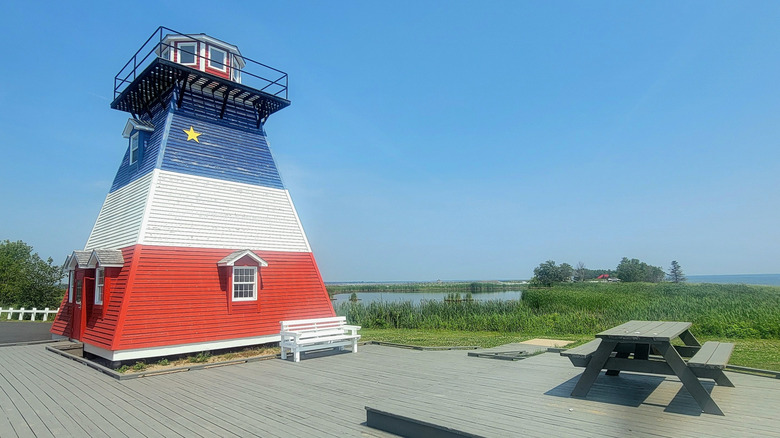 A lighthouse painted red, white, and blue on Hay Island