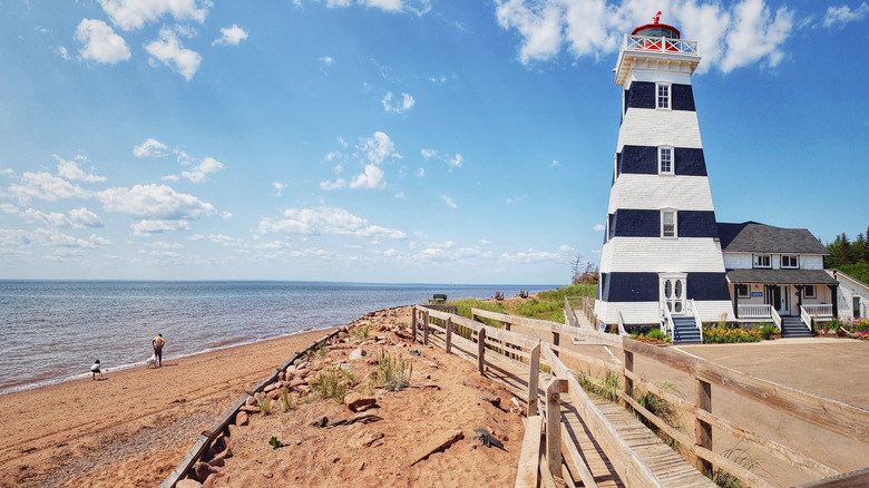 Seascape with beach and striped lighthouse