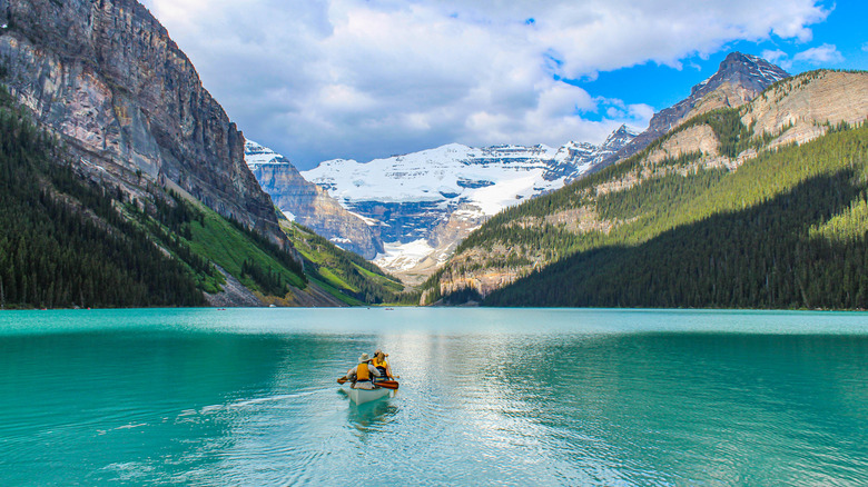 View of a canoe surrounded by mountains on Lake Louise