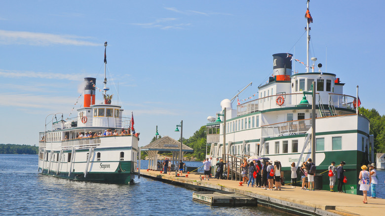Historic steamships docked in Muskoka Wharf in Gravenhurst with tourists preparing to board