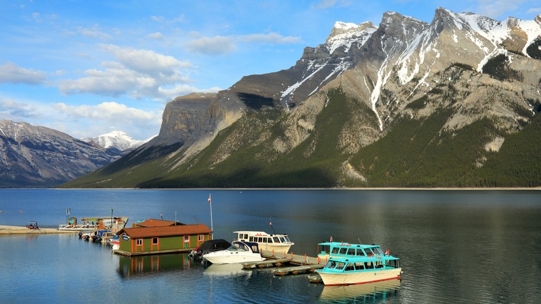 Boats on lake surrounded by mountains