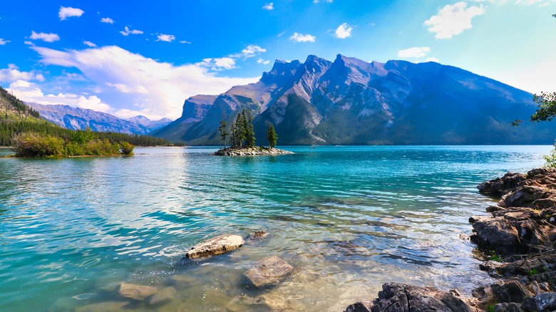 Clear water and rocks at lake edge, with island and mountains