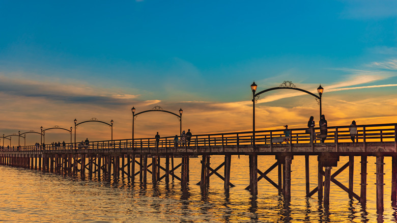 People walking along White Rock Pier at sunset
