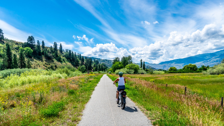 Woman riding an e-bike along a paved trail in Okanagan Valley