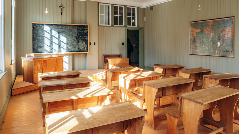Interior image of the Saint-Georges de Val-Jalbert convent-school filled with wooden desks and chairs in in the historic village of Val-Jalbert