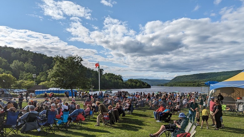 People seated at outdoors festival in Mattawa park in summer