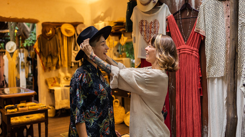 Friends trying on hats at a thrift store
