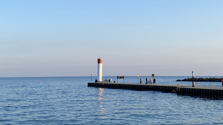 Whitby Pier lighthouse against setting sun and sea