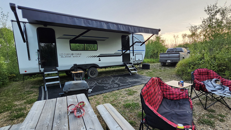 Chairs and a picnic table at an RV campsite at Pinehurst Lake Campground, Alberta