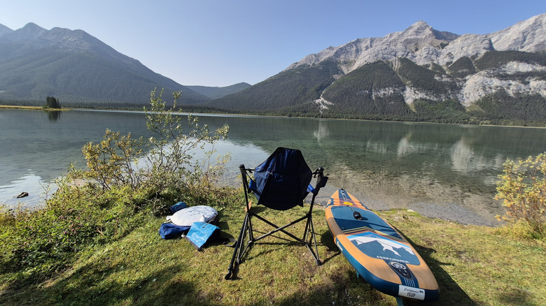 A paddleboard and chair on the shore of Goat Pond in Kananaskis Country
