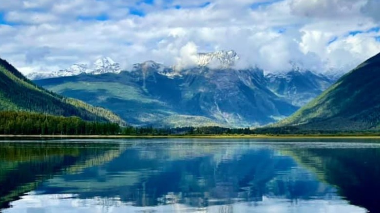 A shot of the glassy surface of Quesnel Lake with mountains in the background, British Columbia, Canada