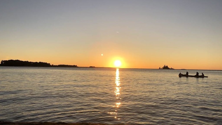 Canoers glide on Lake Nipissing during sunset