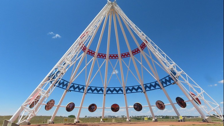 The Saamis Tepee towering in front of a bright blue sky