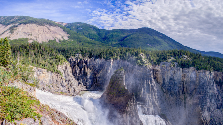 A raging waterfall cascading off a cliff in Nahanni National Park, Northwest Territories, Canada