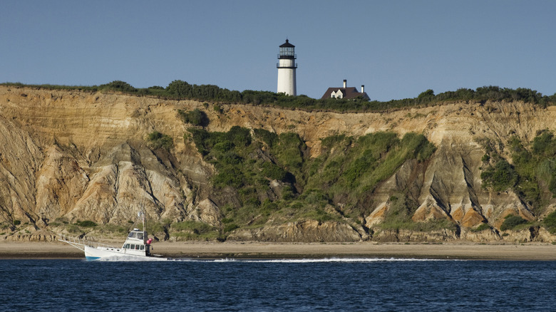 A boat in Cape Cod passing by Highland Lighthouse in Truro