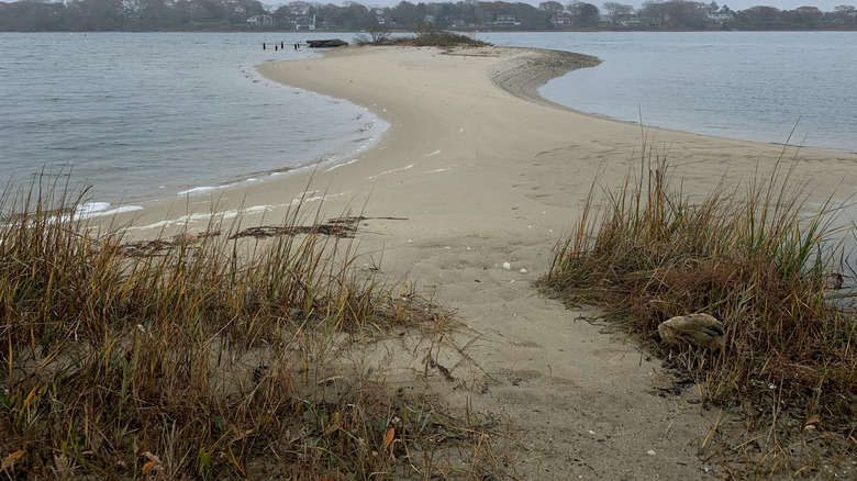 Sandbar dividing the sea against grey sky