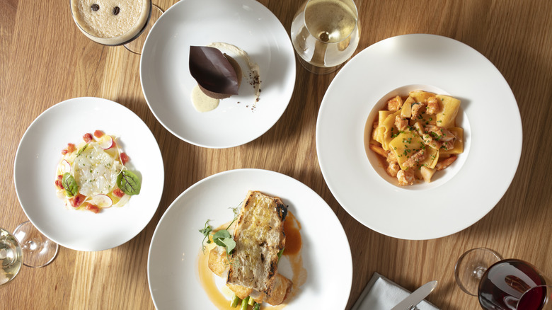 Overhead image of a table laden with four platters of food, three wine glasses, and one espresso martini at the Nassau Paradise Island Wine & Food Festival, in Nassau, Bahamas