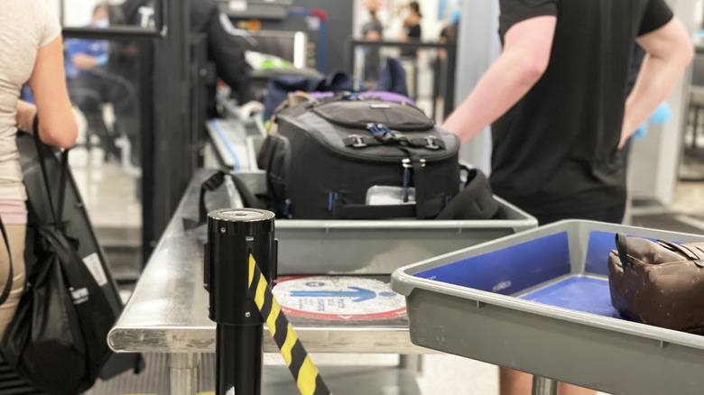 People moving luggage through airport security