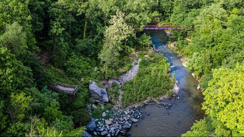 Aerial views of the Black River at Cascade Park in Ohio, with a bridge, an overlook, and surrounded by lush forests
