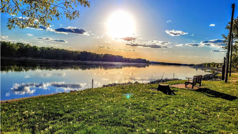 The quaint Riverside Park in Cassville, trimmed grass, a bench, and the Mississippi River