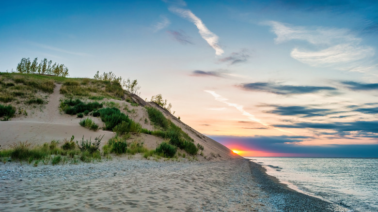 A grassy, sandy dune on the lakeshore in Sleeping Bear Dunes National Lakeshore in Michigan at sunset