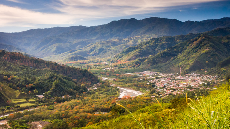a valley in the interior of Costa Rica with a small town, river, framed by mountains